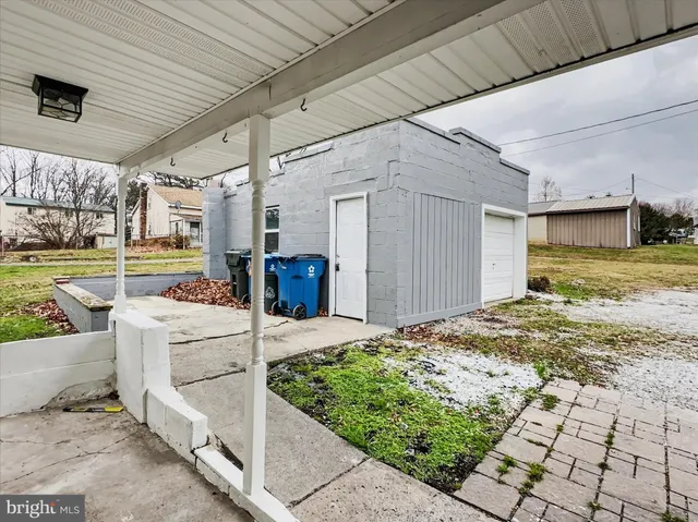 a front view of house with yard and trees in the background