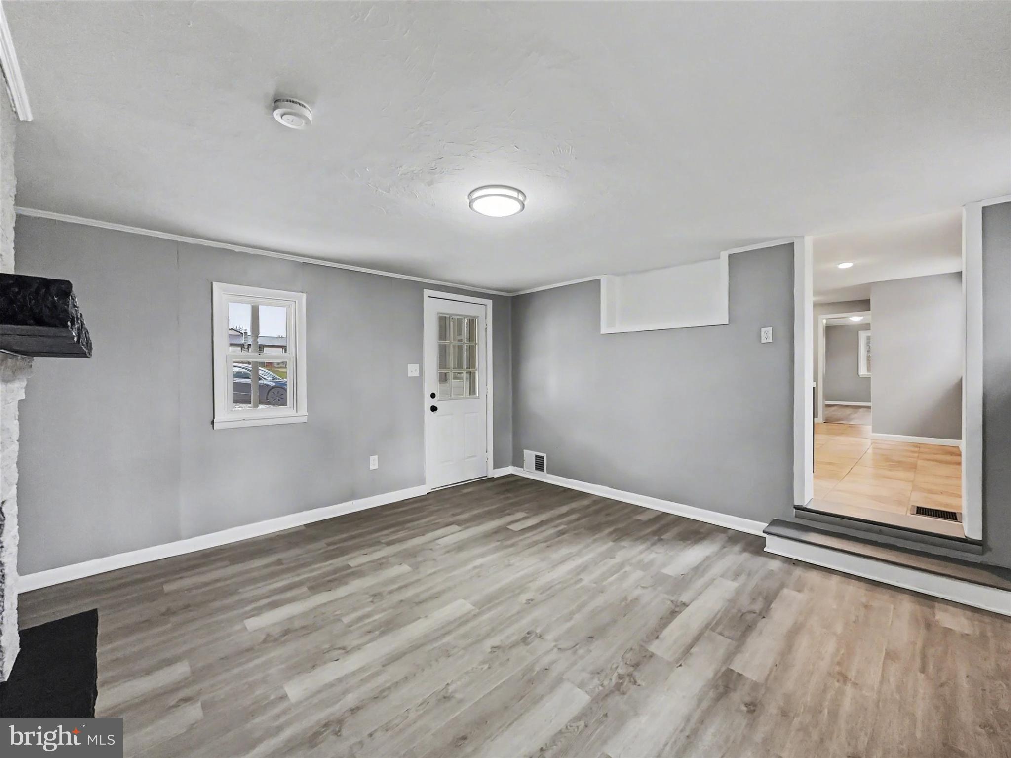 1063 Snyder Corner Road Red Lion, PA 17356 - Photo 5 of 23 a view of an empty room with wooden floor and a window