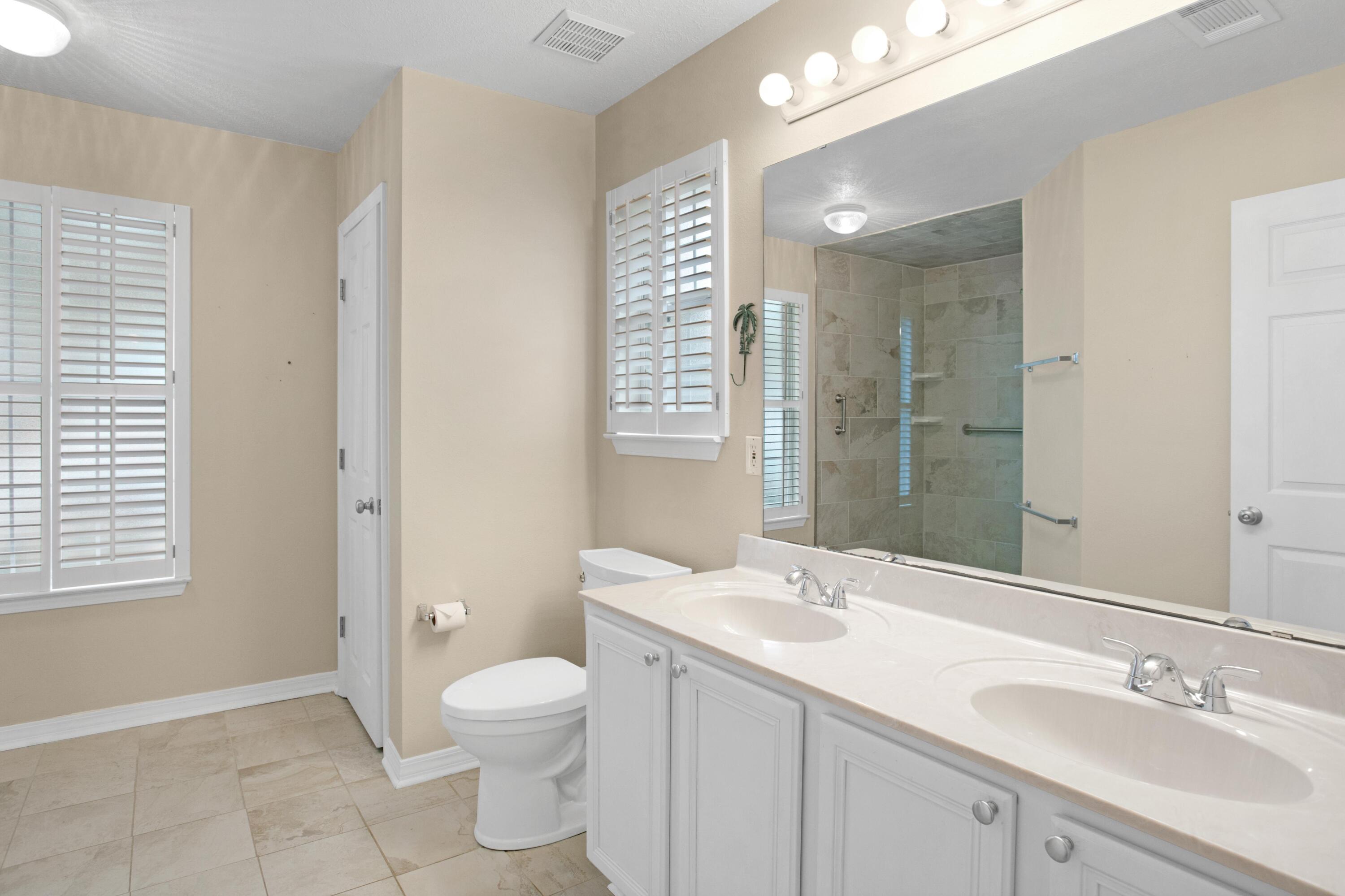 145 Bayou Landing Road Miramar Beach, FL 32550 - Photo 17 of 28 a spacious bathroom with a granite countertop sink toilet a large mirror a vanity and shower
