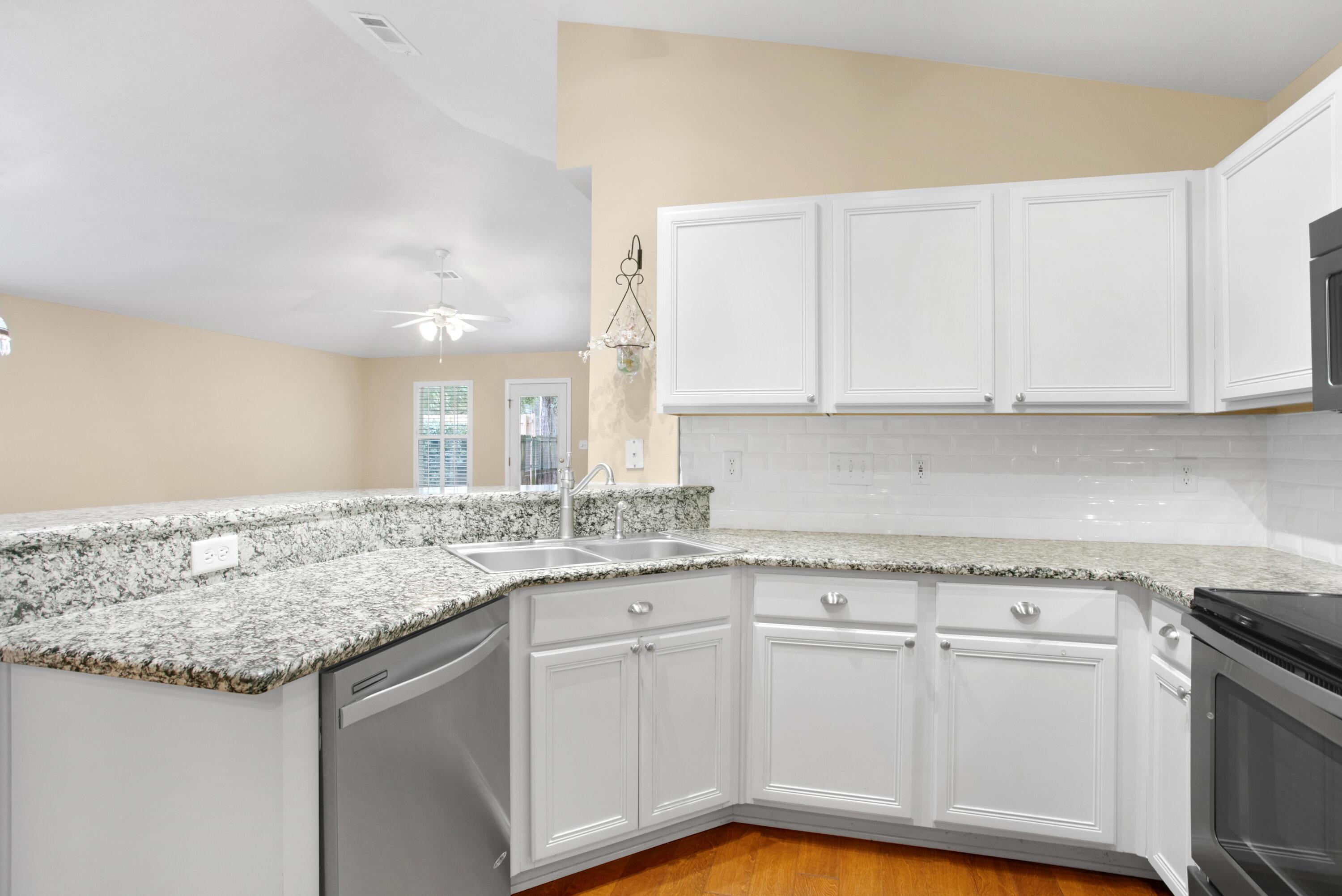 145 Bayou Landing Road Miramar Beach, FL 32550 - Photo 6 of 28 a kitchen with granite countertop white cabinets and a sink