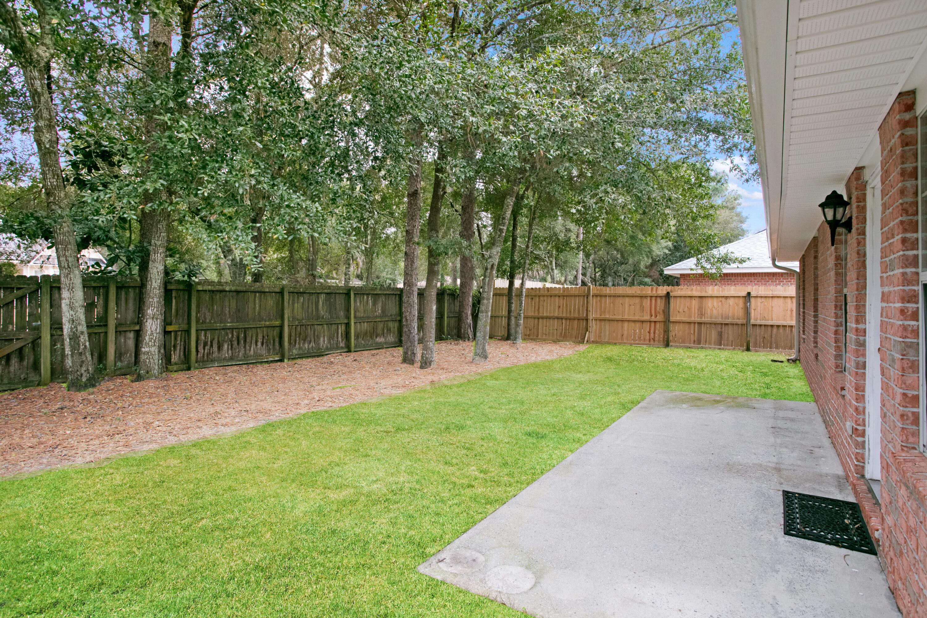 145 Bayou Landing Road Miramar Beach, FL 32550 - Photo 10 of 28 a view of a backyard with wooden fence and a large tree