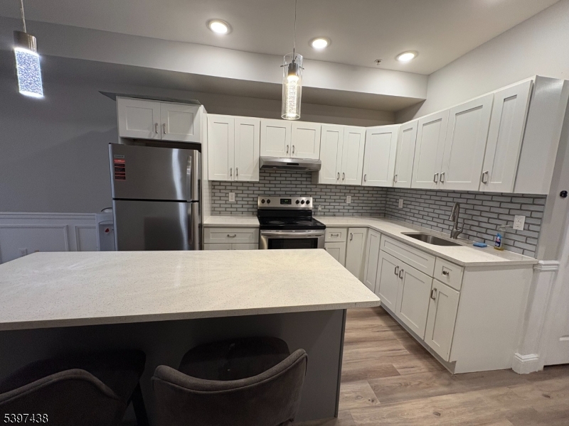 274 Governor Street Paterson, NJ 07501 - Photo 4 of 14 a kitchen with kitchen island a sink stainless steel appliances and counter space