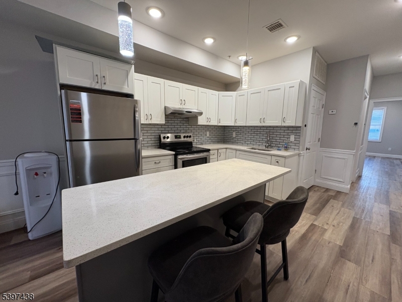 274 Governor Street Paterson, NJ 07501 - Photo 7 of 14 a kitchen with refrigerator cabinets and wooden floor