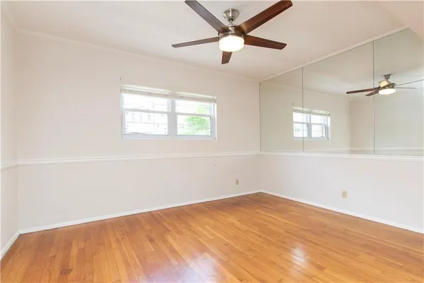 an empty room with a window and a fan