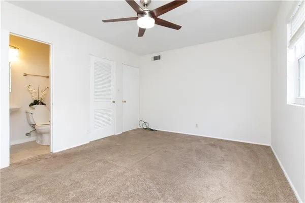 an empty room with a window and a ceiling fan