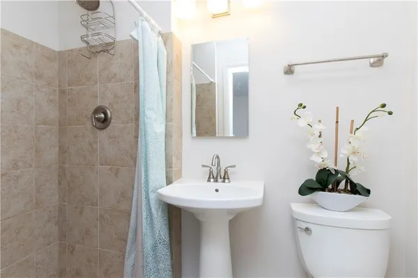 a bathroom with a sink a toilet and shower