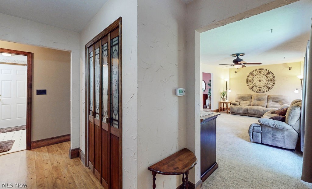 Hallway featuring light colored carpet