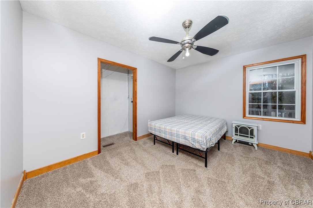 9534 Gee Farm Road Gloucester, VA 23061 - Photo 23 of 48 Carpeted bedroom featuring ceiling fan and a textured ceiling