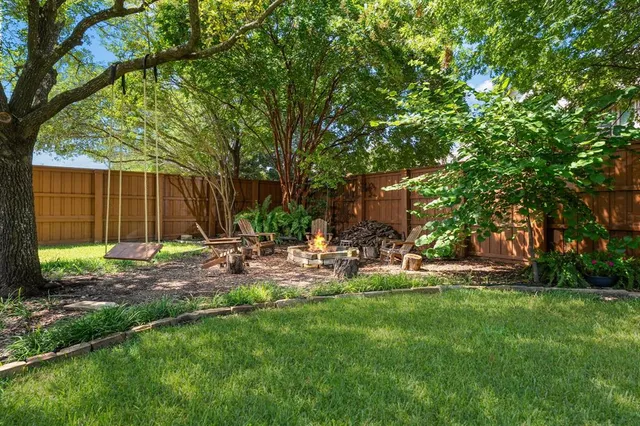 a view of a patio with table and chairs under an umbrella with a big yard