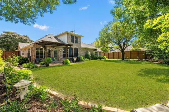 a view of backyard with table and chairs and wooden fence