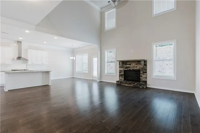 a view of an empty room with fireplace and wooden floor
