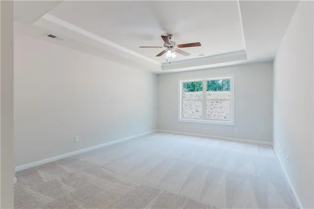 an empty room with a window and a ceiling fan