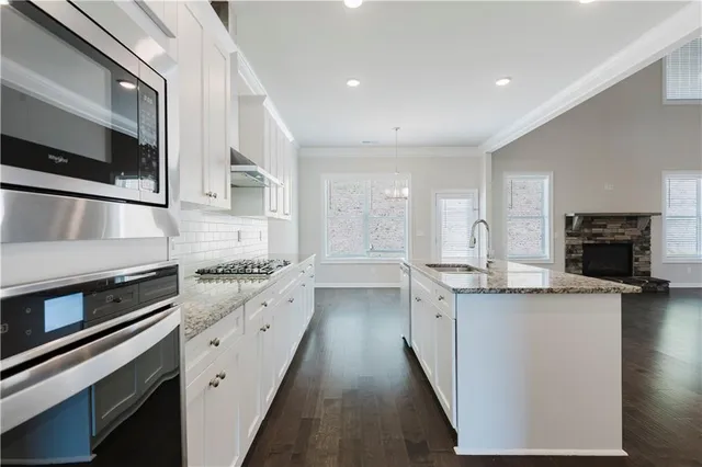 a kitchen with stainless steel appliances granite countertop a stove and a sink