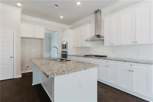 a kitchen with stainless steel appliances granite countertop a sink stove and cabinets