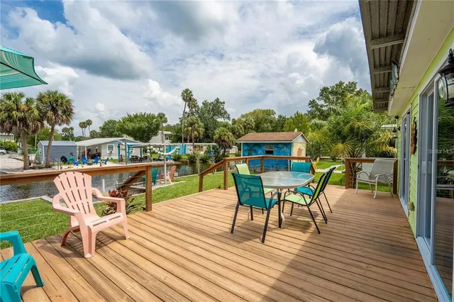 a balcony with wooden floor table and chairs