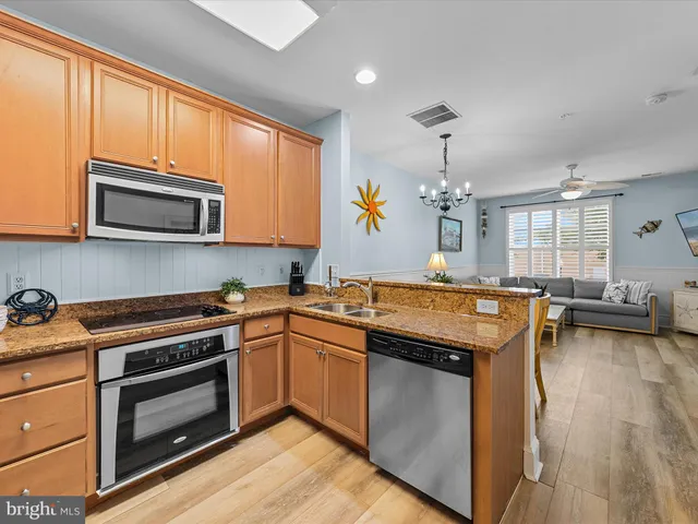 a kitchen with stainless steel appliances granite countertop a stove a microwave a sink and cabinets