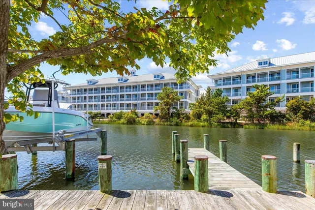 a view of a lake with a table and chairs next to a yard