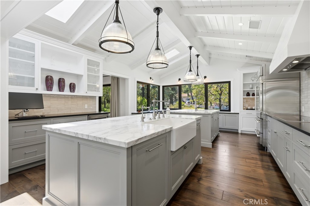 24884 Jim Bridger Road Hidden Hills, CA 91302 - Photo 7 of 31 a large white kitchen with a large center island and stainless steel appliances