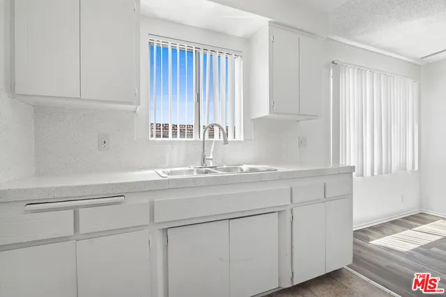 a kitchen with white cabinets and a sink