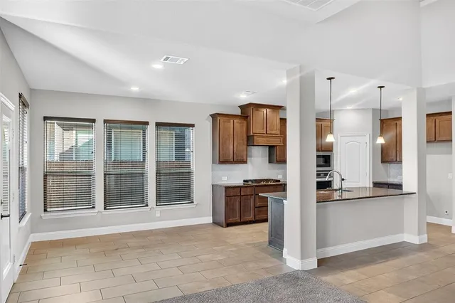 a view of kitchen with stainless steel appliances granite countertop cabinets and a counter top space