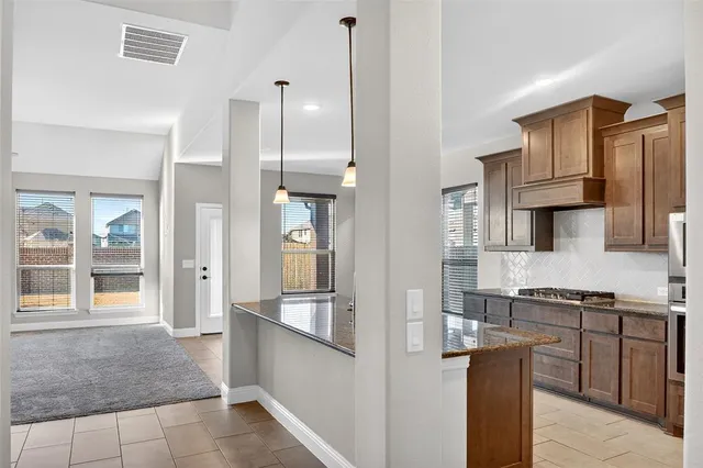 a kitchen with stainless steel appliances granite countertop a refrigerator and stove