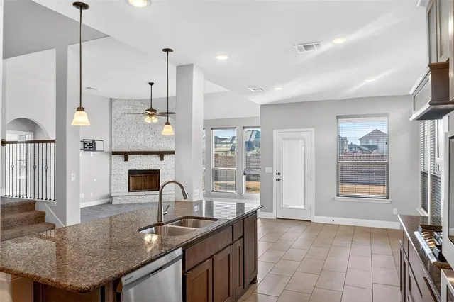 a kitchen with granite countertop a sink a counter top space and stainless steel appliances