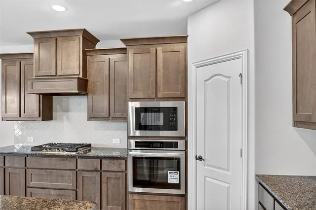 a kitchen with granite countertop a stove and a refrigerator