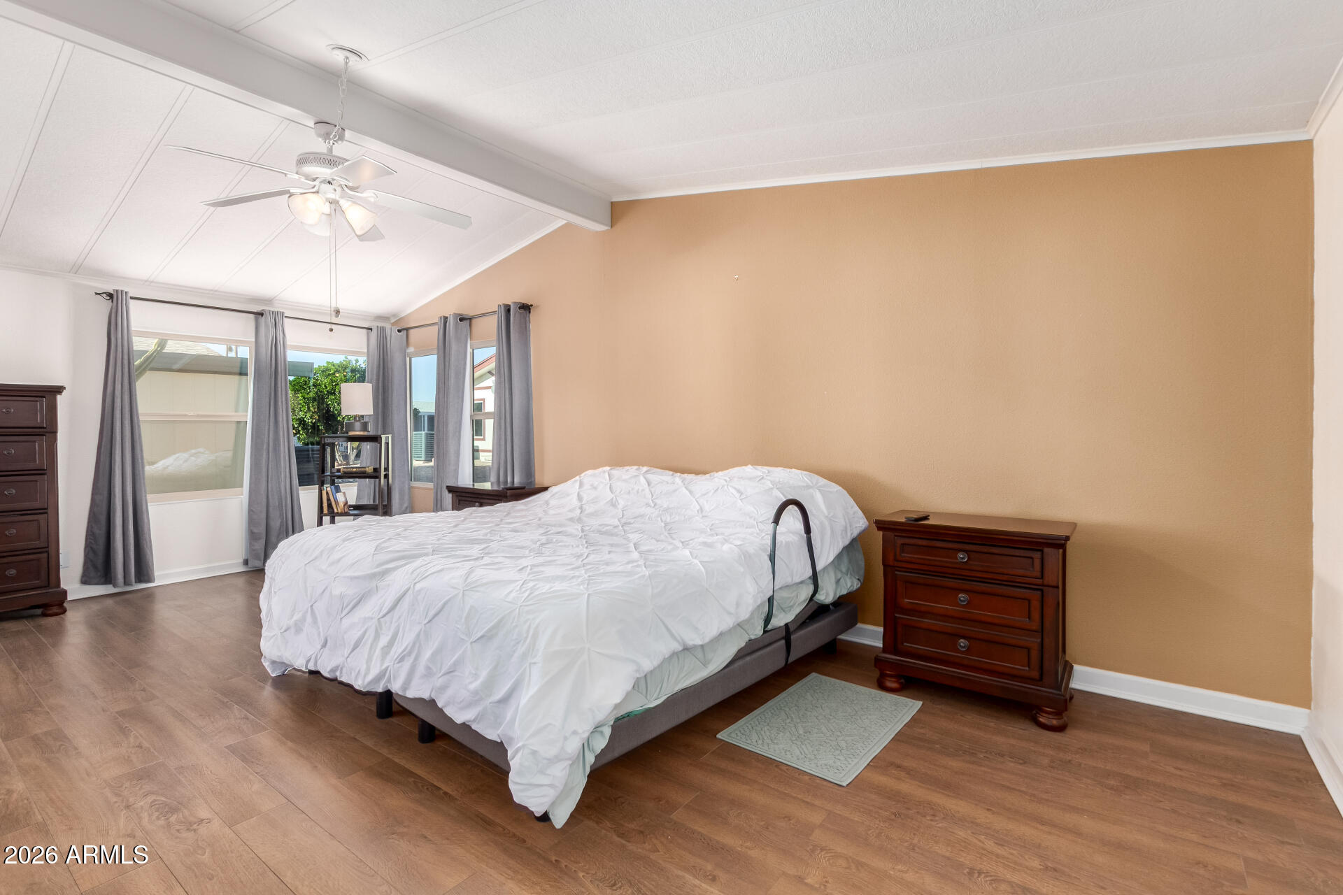 5402 East McKellips Road, Unit 186 Mesa, AZ 85215 - Photo 16 of 27 a bedroom with a bed and dresser with wooden floor