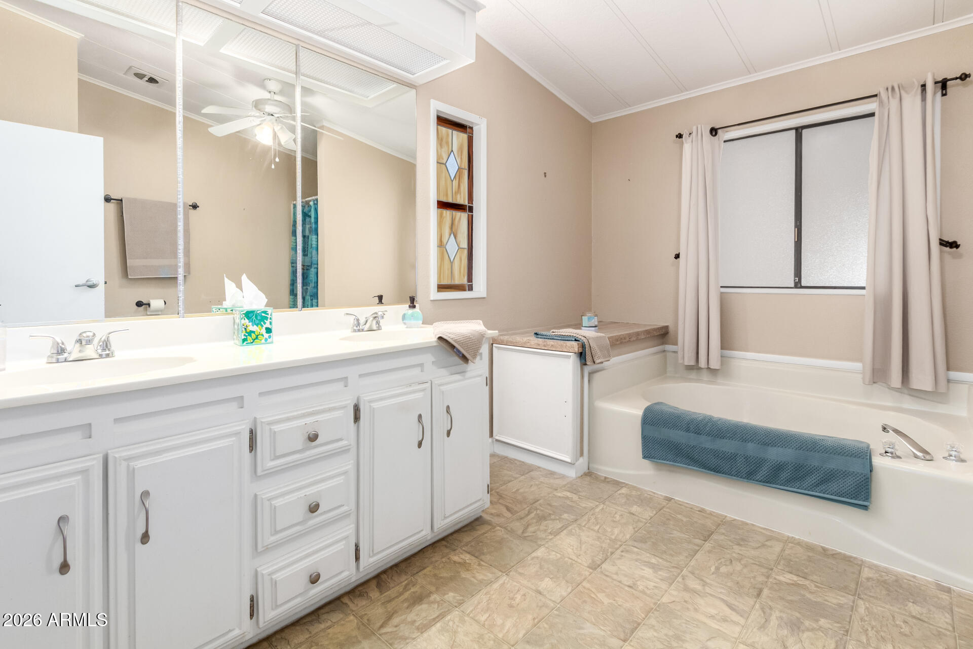 5402 East McKellips Road, Unit 186 Mesa, AZ 85215 - Photo 19 of 27 a spacious bathroom with double vanity a mirror a bathtub and a double vanity sink