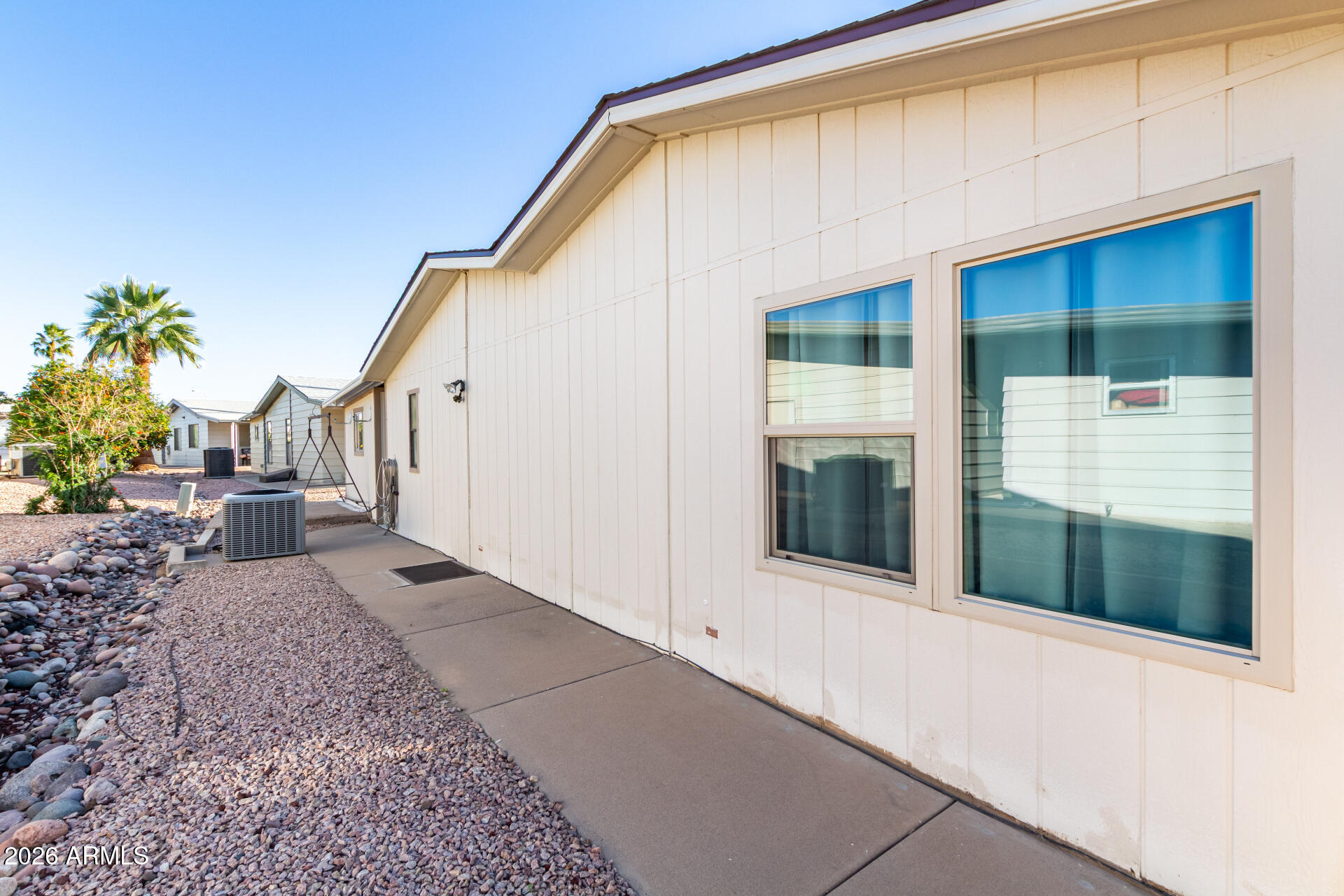 5402 East McKellips Road, Unit 186 Mesa, AZ 85215 - Photo 25 of 27 a view of a house with a small yard and floor to ceiling window