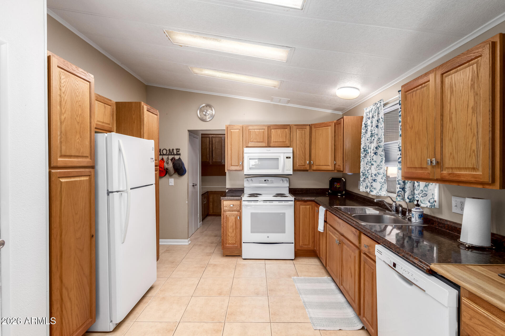 5402 East McKellips Road, Unit 186 Mesa, AZ 85215 - Photo 9 of 27 a kitchen with a refrigerator a stove top oven a sink and dishwasher