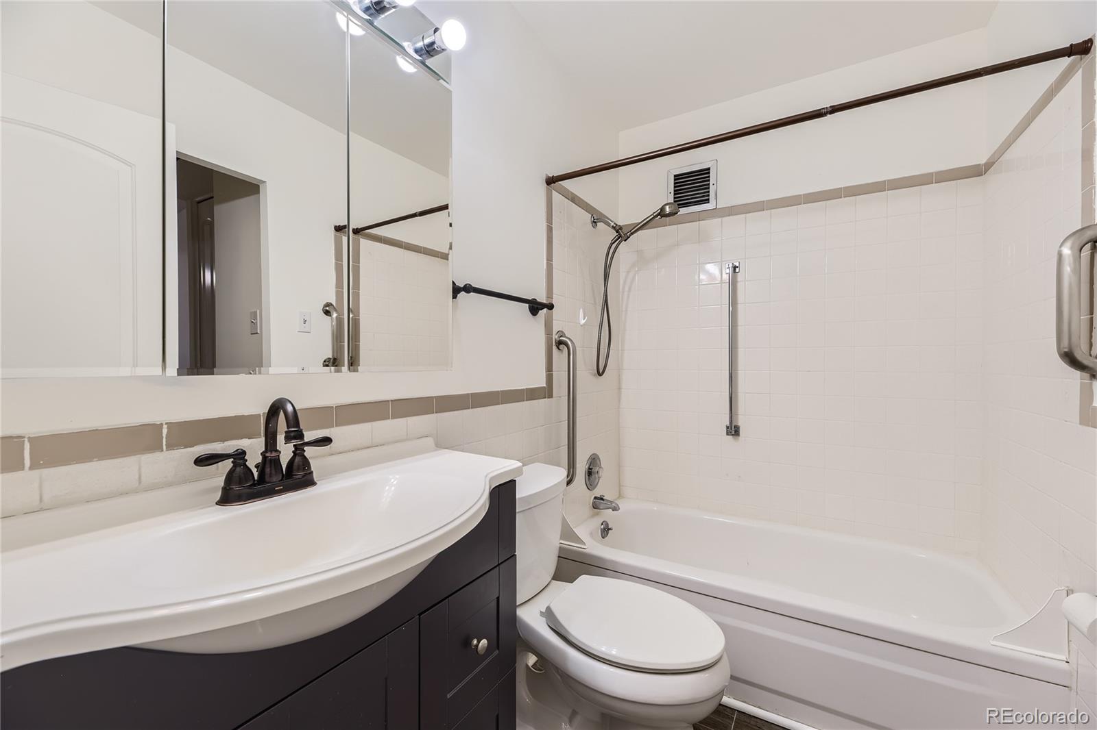 735 South Clinton Street, Unit 5B Denver, CO 80247 - Photo 8 of 15 a bathroom with a sink a toilet and a mirror