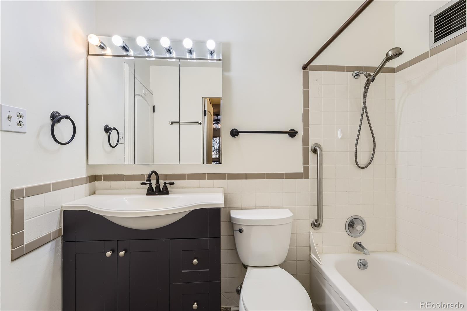 735 South Clinton Street, Unit 5B Denver, CO 80247 - Photo 10 of 15 a bathroom with a sink vanity mirror and toilet