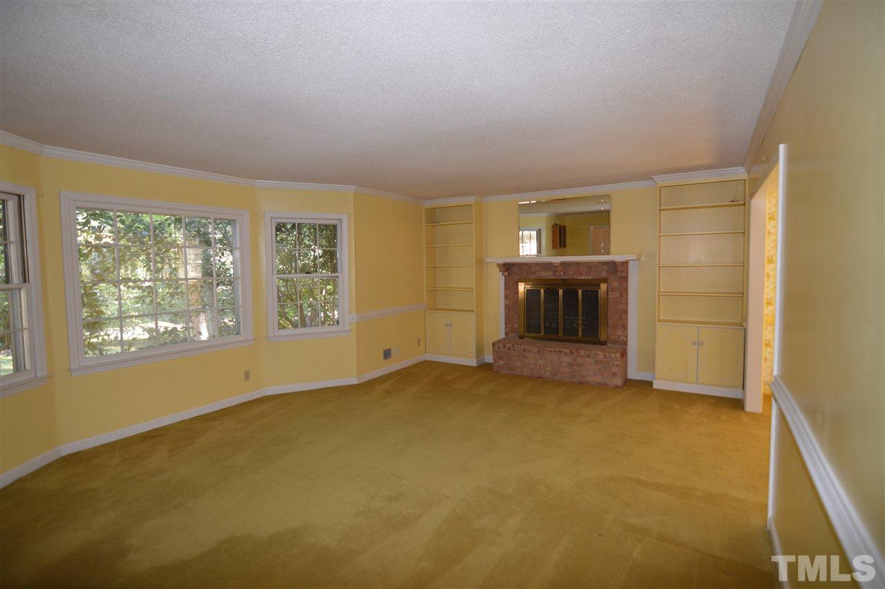 112 Bayleaf Drive Raleigh, NC 27615 - Photo 5 of 25 Living room has built in bookcases and a raised fireplace hearth. there are hardwoods under the carpet.