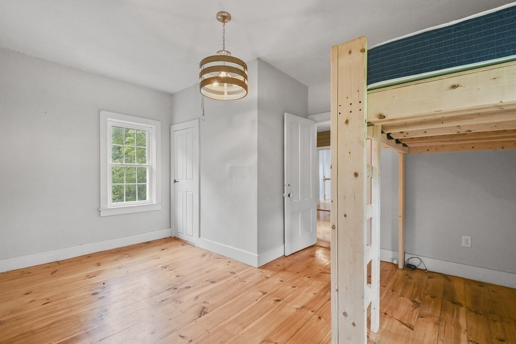 235 Manchaug Road Sutton, MA 01590 - Photo 32 of 41 a view of an empty room with window and wooden floor