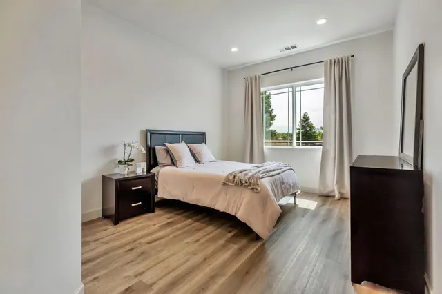 a bathroom with a toilet a sink and wooden floor