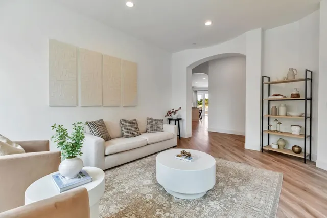 a living room with furniture kitchen area and a large window