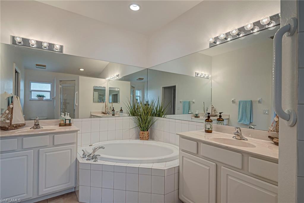 7809 Stratford Drive Naples, FL 34104 - Photo 14 of 47 a bathroom with a sink a large mirror and a bathtub
