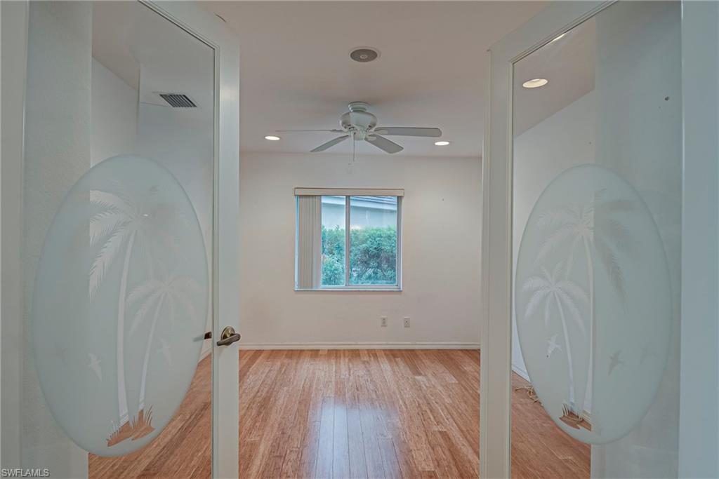 7809 Stratford Drive Naples, FL 34104 - Photo 15 of 47 wooden floor in an empty room with a window