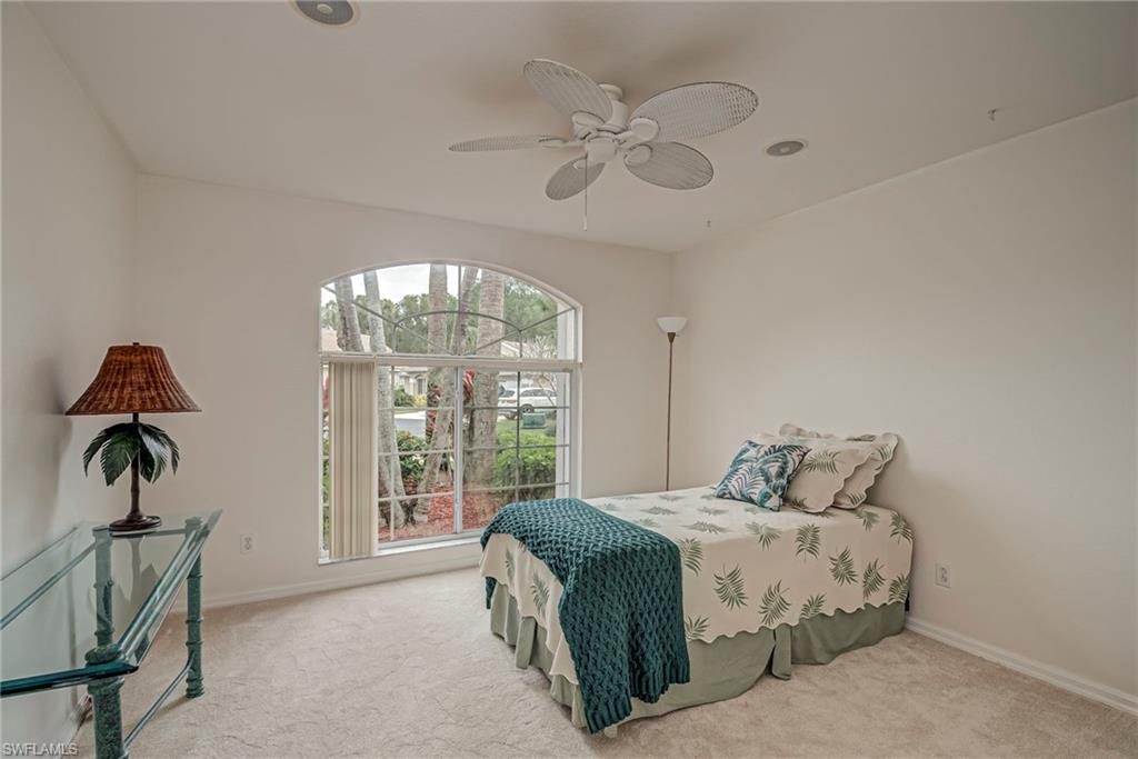 7809 Stratford Drive Naples, FL 34104 - Photo 18 of 47 a bedroom with a bed and a chandelier