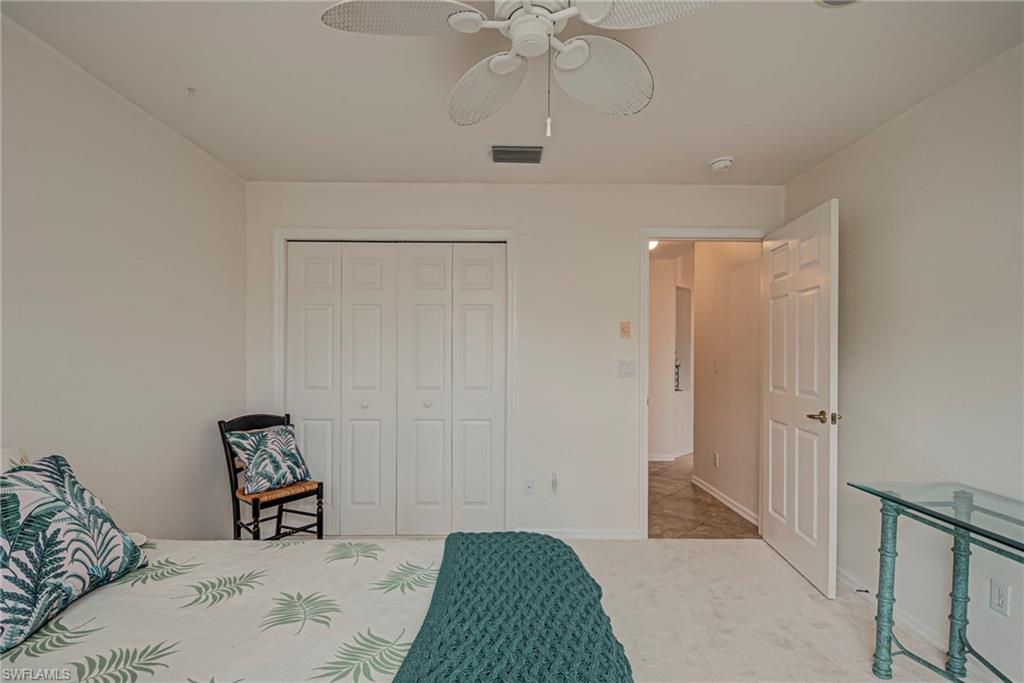 7809 Stratford Drive Naples, FL 34104 - Photo 19 of 47 a bedroom with a bed and a chandelier