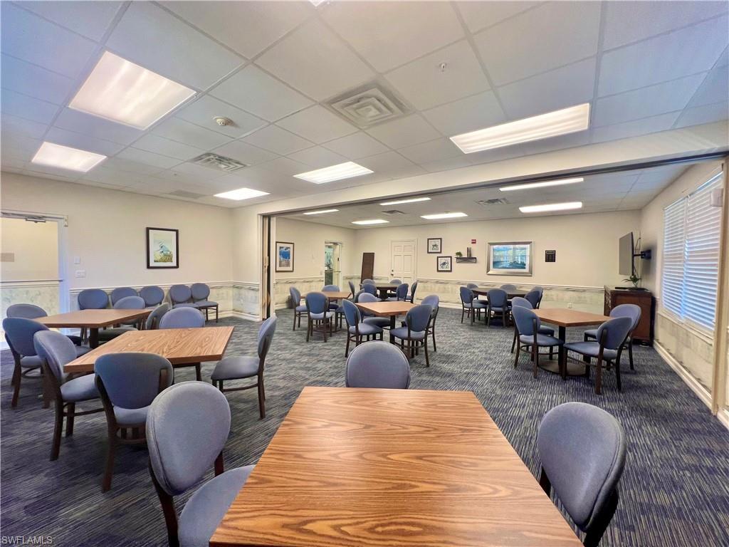 7809 Stratford Drive Naples, FL 34104 - Photo 38 of 47 a living room with furniture a rug kitchen view and a chandelier
