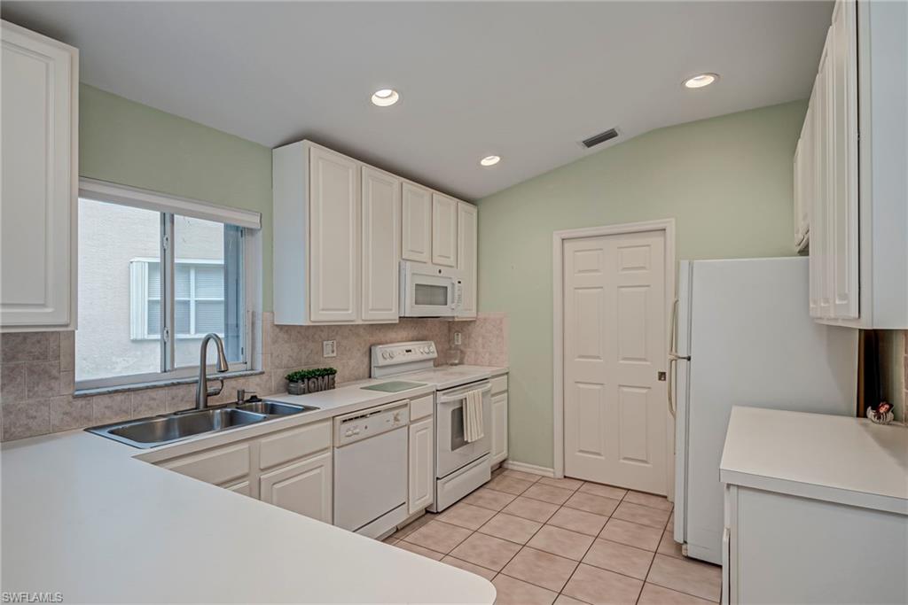 7809 Stratford Drive Naples, FL 34104 - Photo 7 of 47 a kitchen with a sink cabinets and window