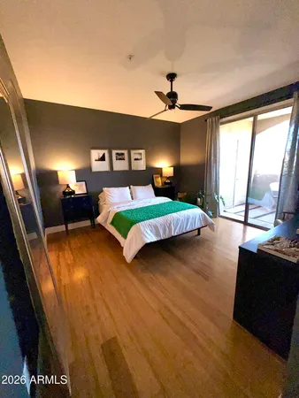 a bedroom with a bed and a flat tv screen on dresser