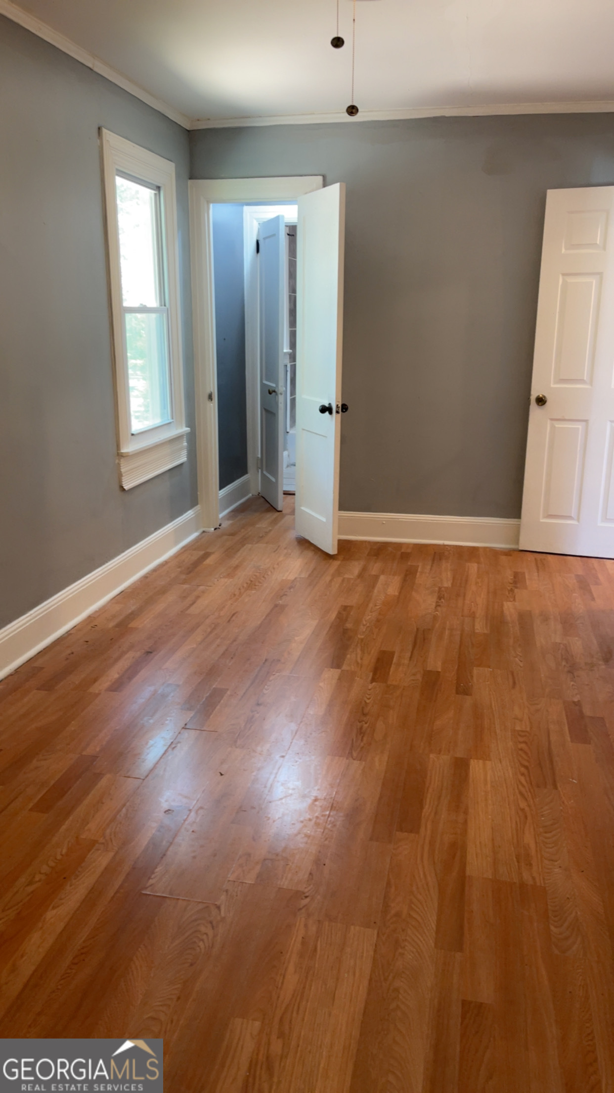 1312 Gillespie Avenue, Unit C Albany, GA 31707 - Photo 3 of 9 an empty room with wooden floor and windows