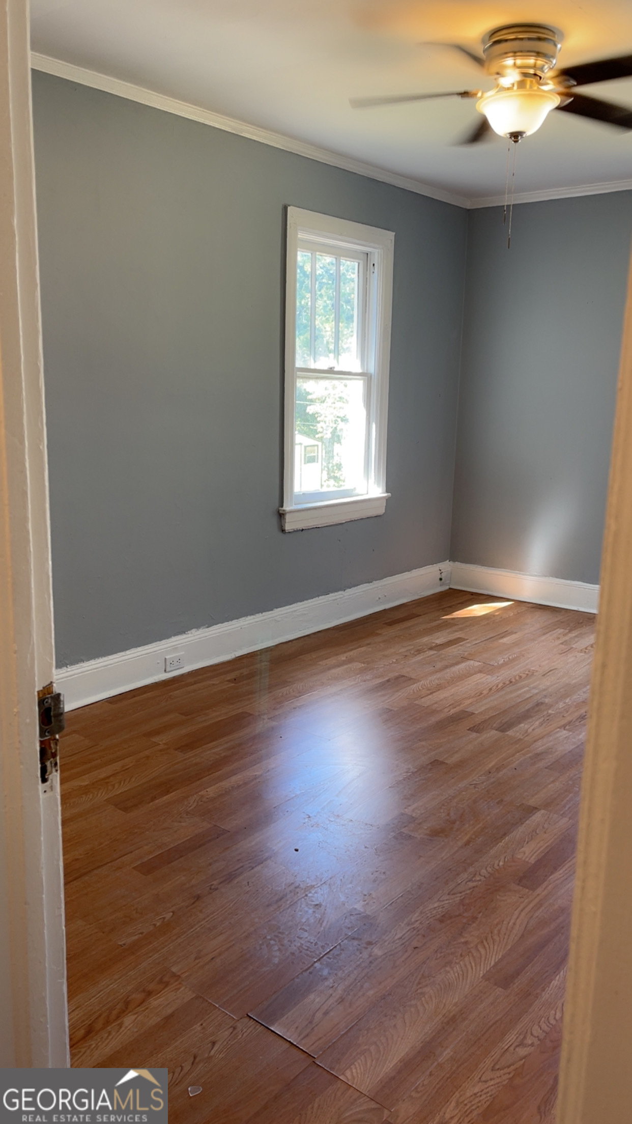 1312 Gillespie Avenue, Unit C Albany, GA 31707 - Photo 6 of 9 an empty room with wooden floor and windows