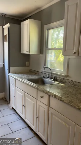 a bathroom with a granite countertop sink and a window
