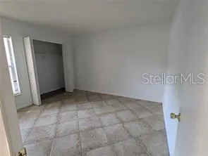 a view of an empty room with window and stairs