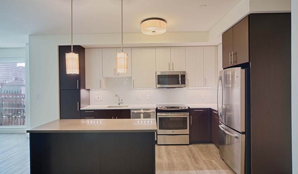 a kitchen with stainless steel appliances granite countertop a refrigerator and a sink