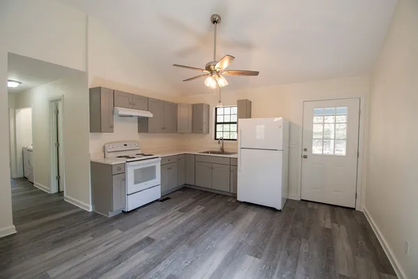 a kitchen with white cabinets and white appliances